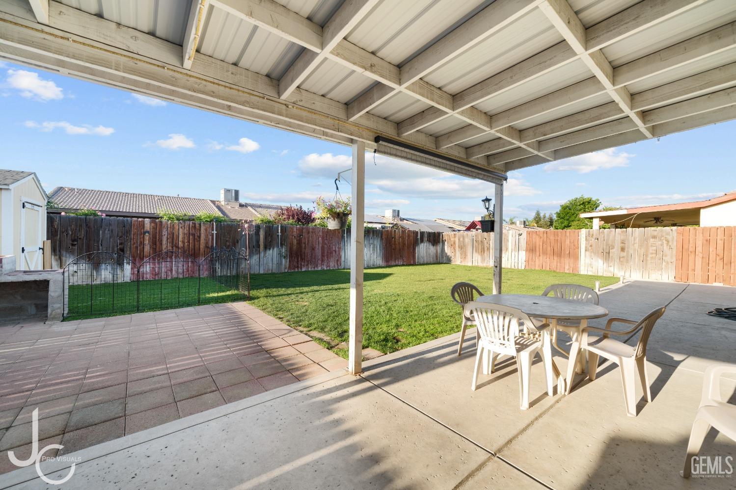 Undisclosed Address Bakersfield, CA 93307 - Photo 25 of 31 a view of a patio with a table chairs and a backyard