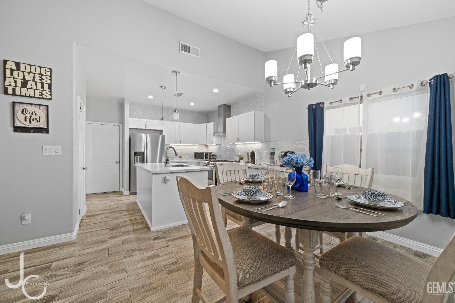 Undisclosed Address Bakersfield, CA 93307 - Photo 9 of 31 a view of a dining room and livingroom view with furniture wooden floor a chandelier