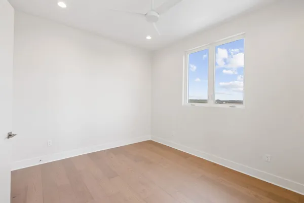 a view of a kitchen with white cabinets and wooden floor