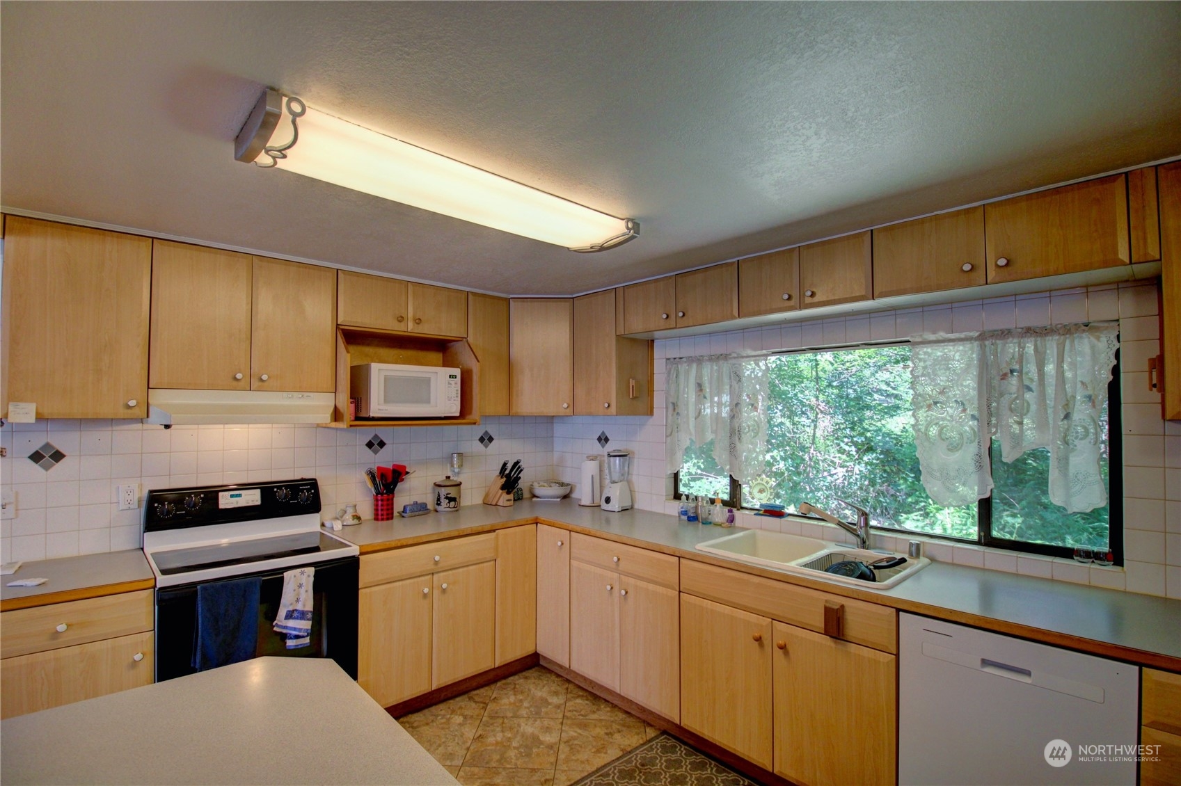 16105 OK Mill Road Snohomish, WA 98290 - Photo 9 of 34 a kitchen with a sink stove top oven and cabinets