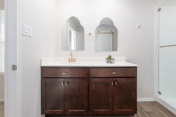 a bathroom with a double vanity sink mirror and shower