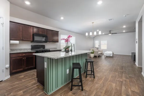 a kitchen with granite countertop a sink cabinets and stainless steel appliances