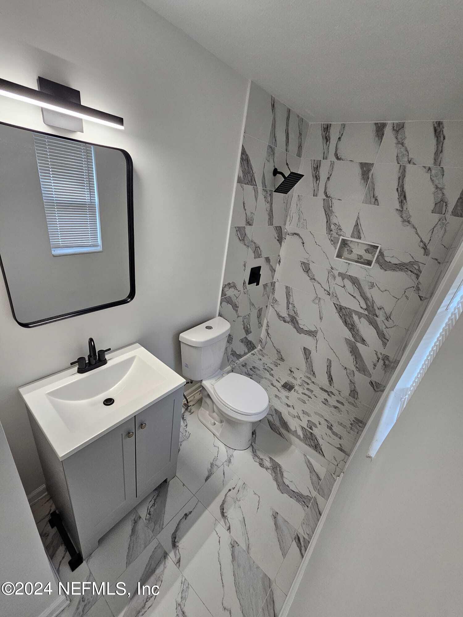 7504 Wheat Road Jacksonville, FL 32244 - Photo 12 of 31 a bathroom with a sink toilet and mirror