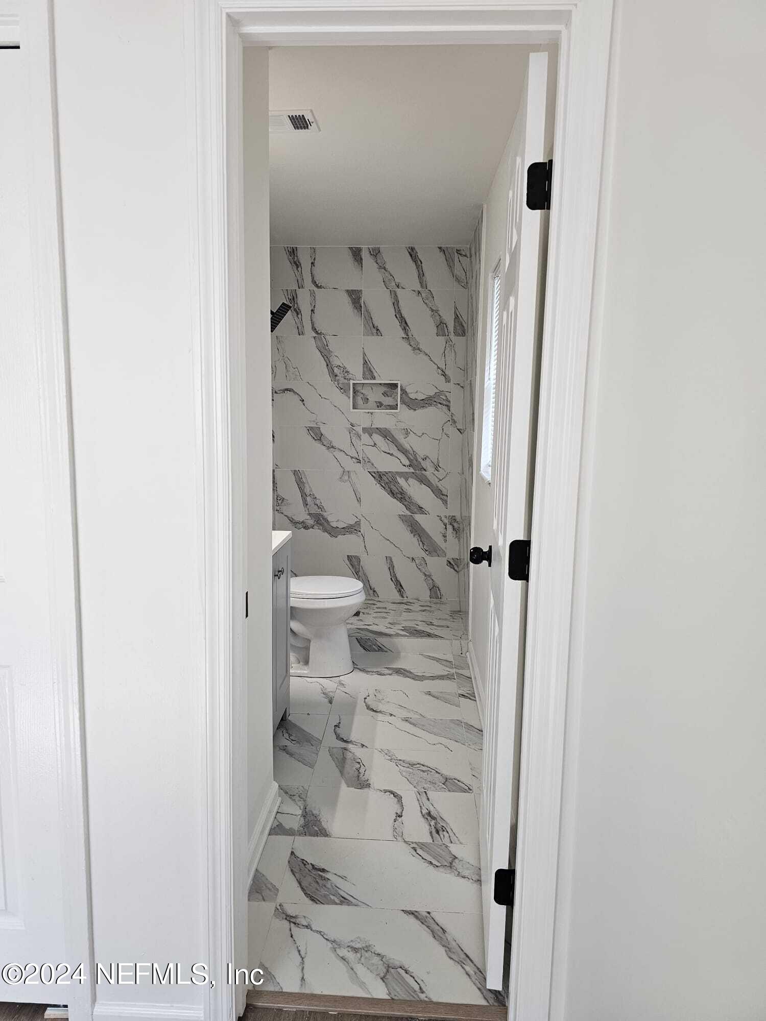 7504 Wheat Road Jacksonville, FL 32244 - Photo 13 of 31 a bathroom with a shower and a glass door