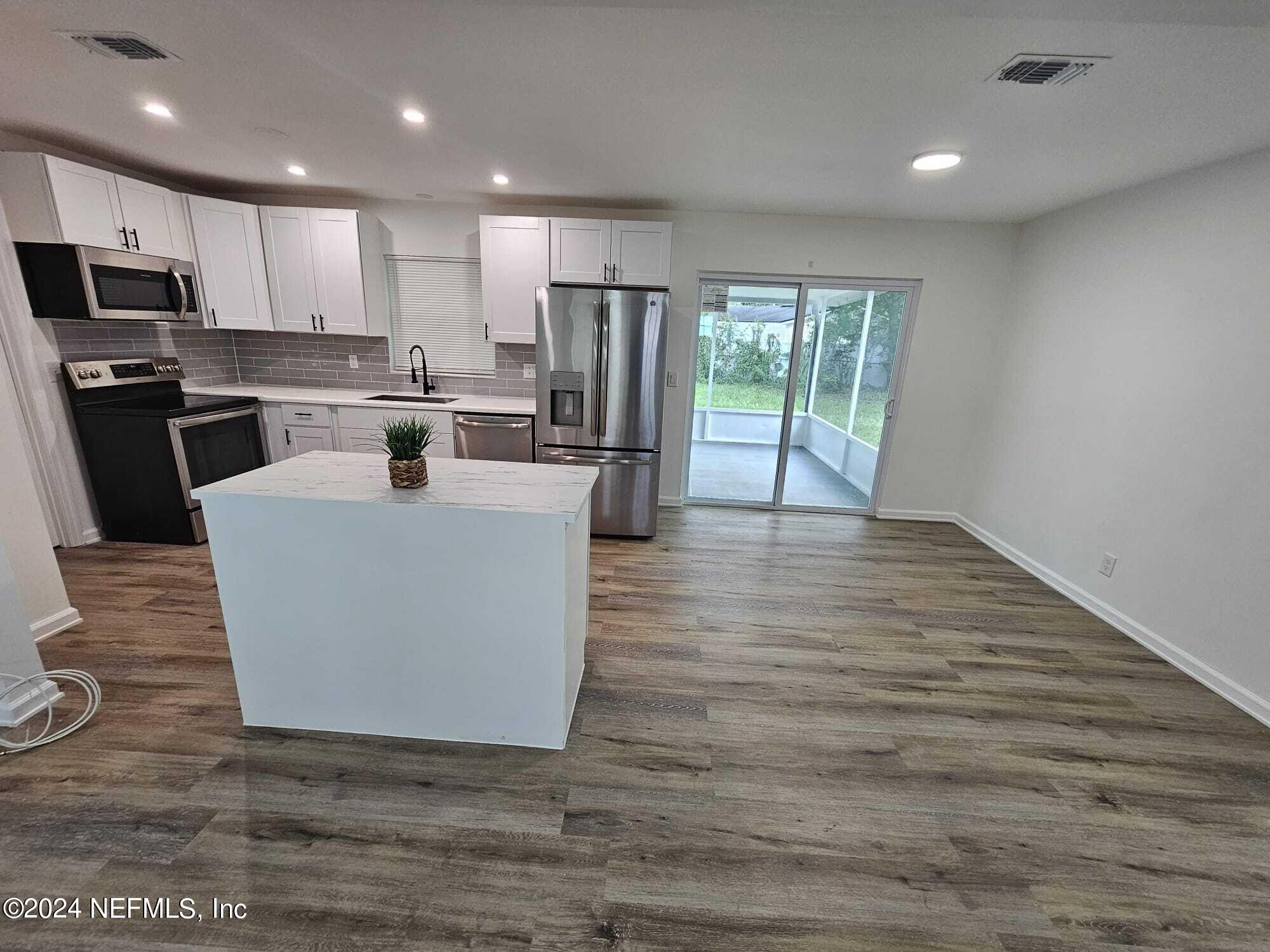 7504 Wheat Road Jacksonville, FL 32244 - Photo 18 of 31 a large kitchen with granite countertop a large counter top stainless steel appliances and cabinets