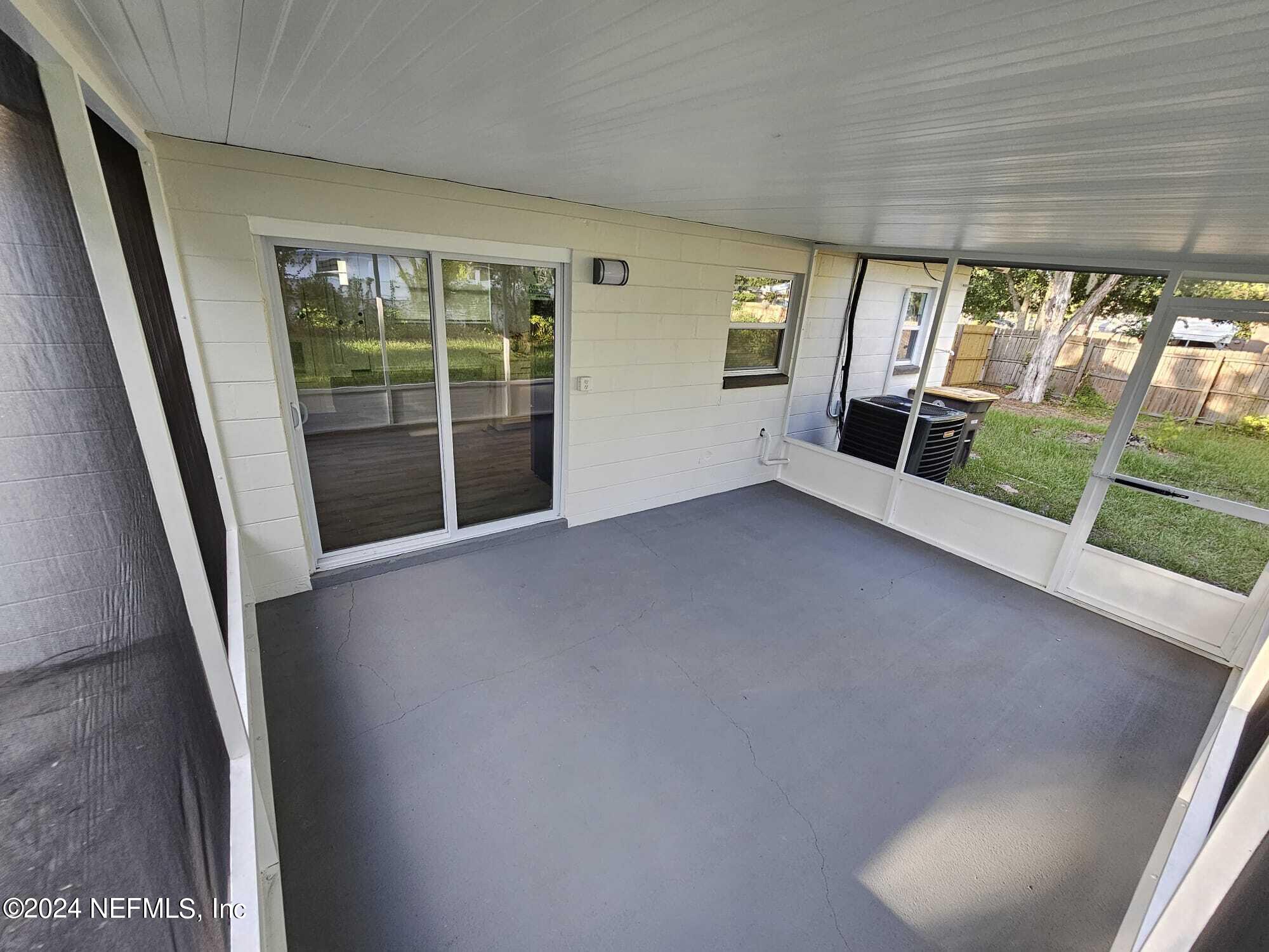 7504 Wheat Road Jacksonville, FL 32244 - Photo 28 of 31 a view of an empty room with wooden floor and a window