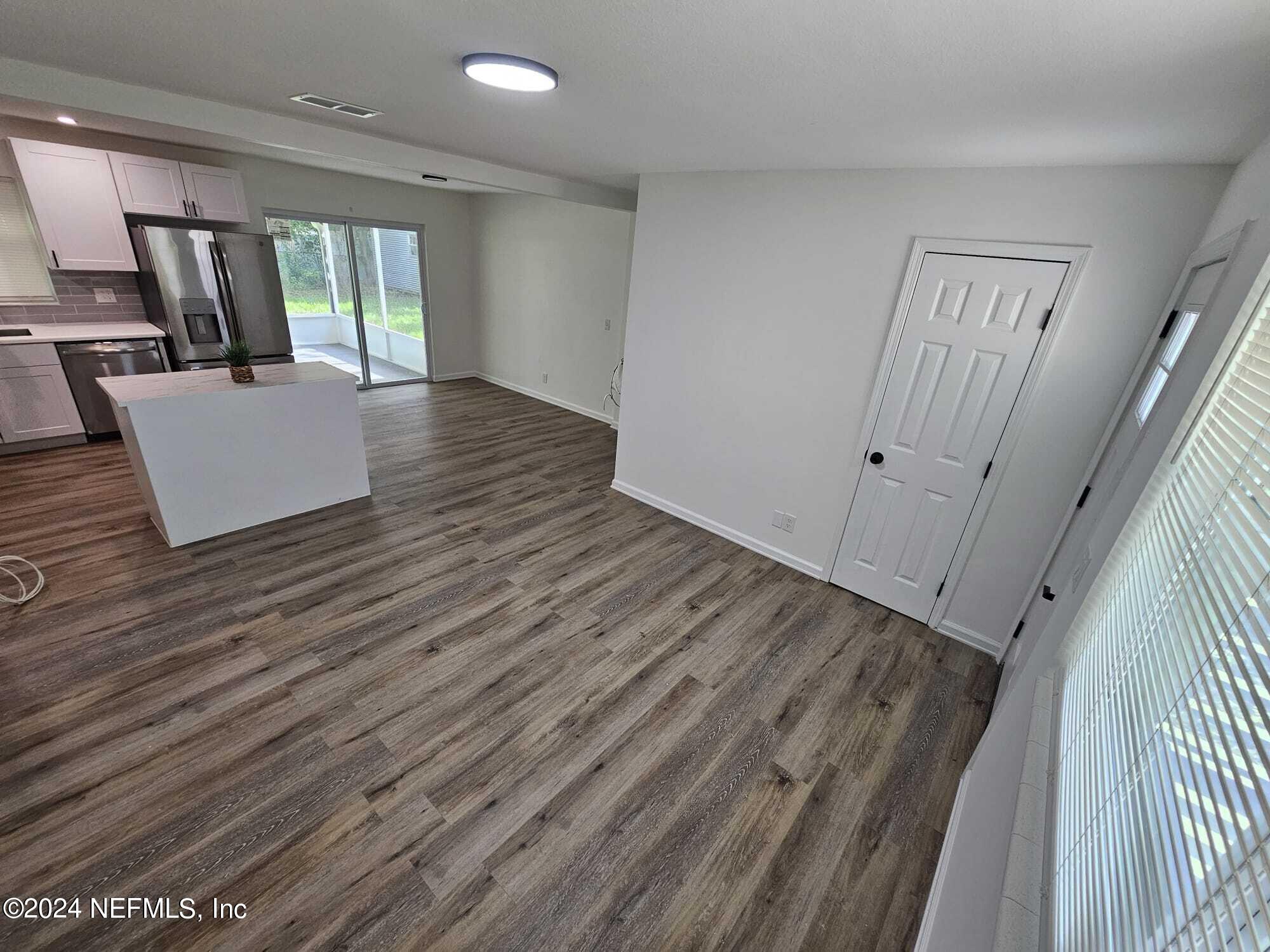 7504 Wheat Road Jacksonville, FL 32244 - Photo 4 of 31 a view of an empty room with wooden floor and a window