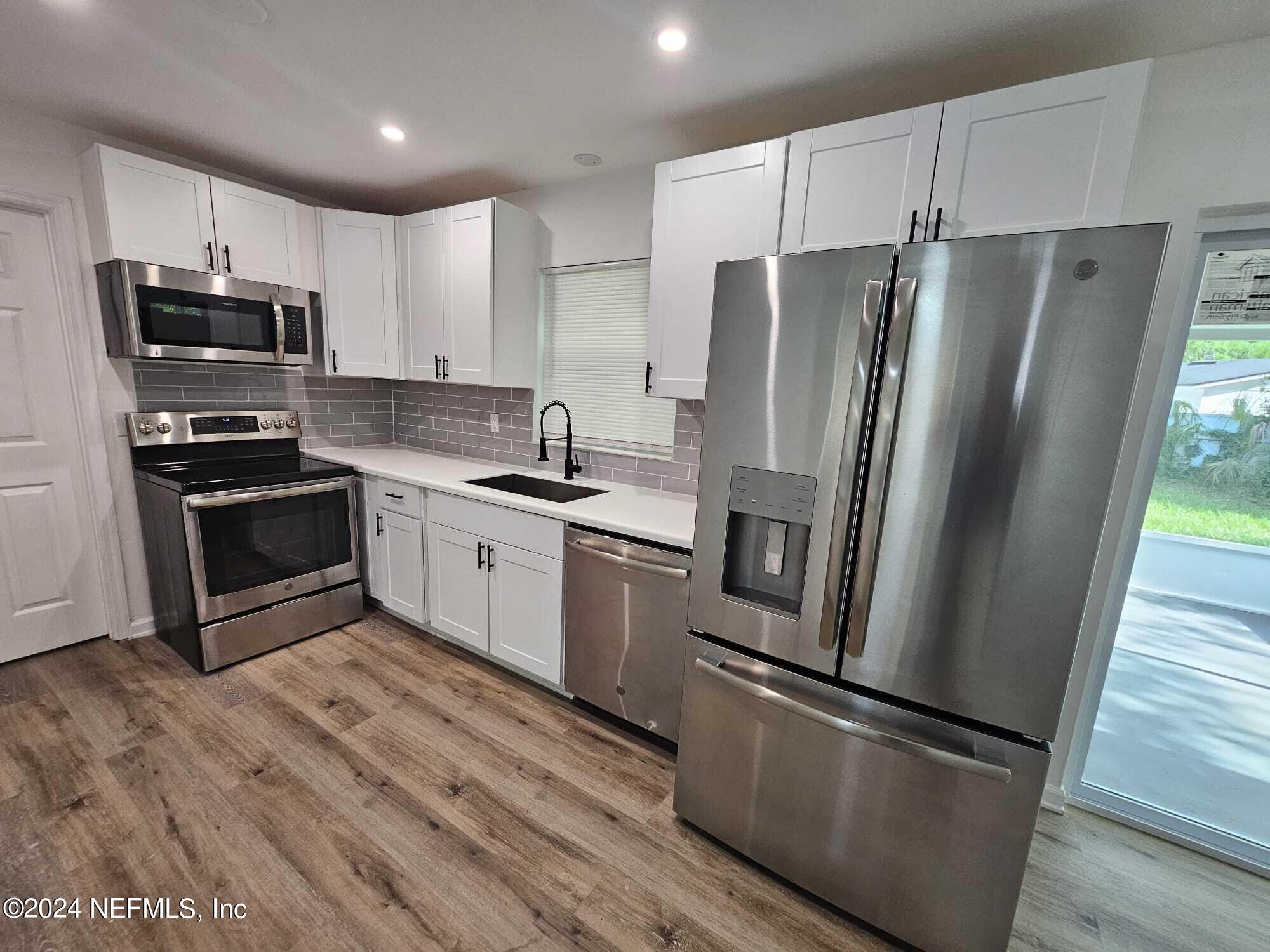 7504 Wheat Road Jacksonville, FL 32244 - Photo 6 of 31 a kitchen with stainless steel appliances a refrigerator sink and microwave