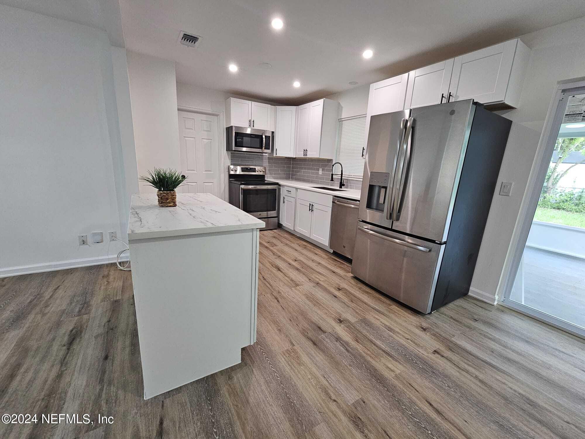 7504 Wheat Road Jacksonville, FL 32244 - Photo 7 of 31 a kitchen with a refrigerator a sink and dishwasher