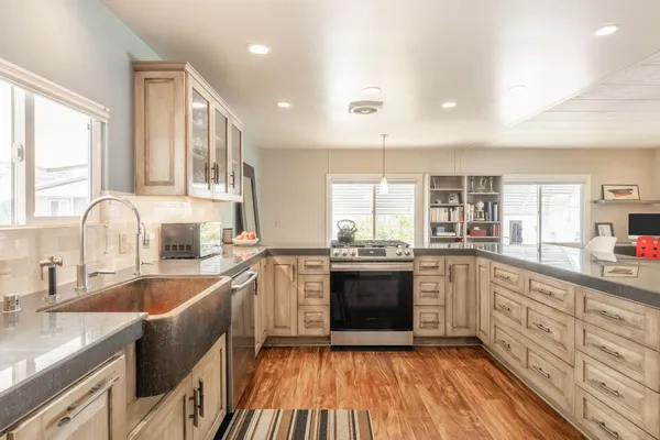 a kitchen with stainless steel appliances granite countertop a sink stove and refrigerator