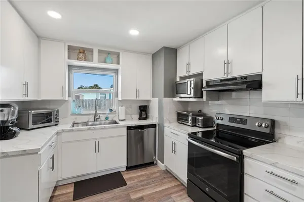 a kitchen with a sink stove and microwave