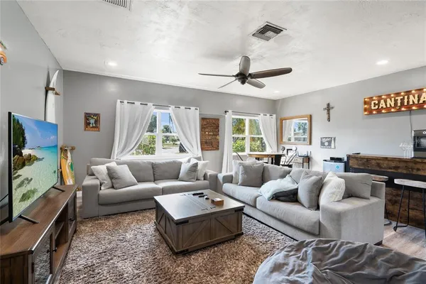 a living room with furniture ceiling fan and a window