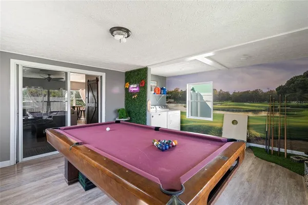 a room with pool table and windows