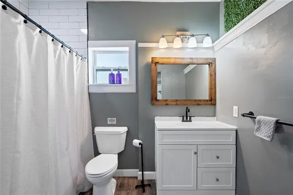 a bathroom with a sink vanity mirror and toilet
