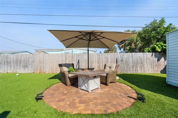 a view of a backyard with table and chairs under an umbrella