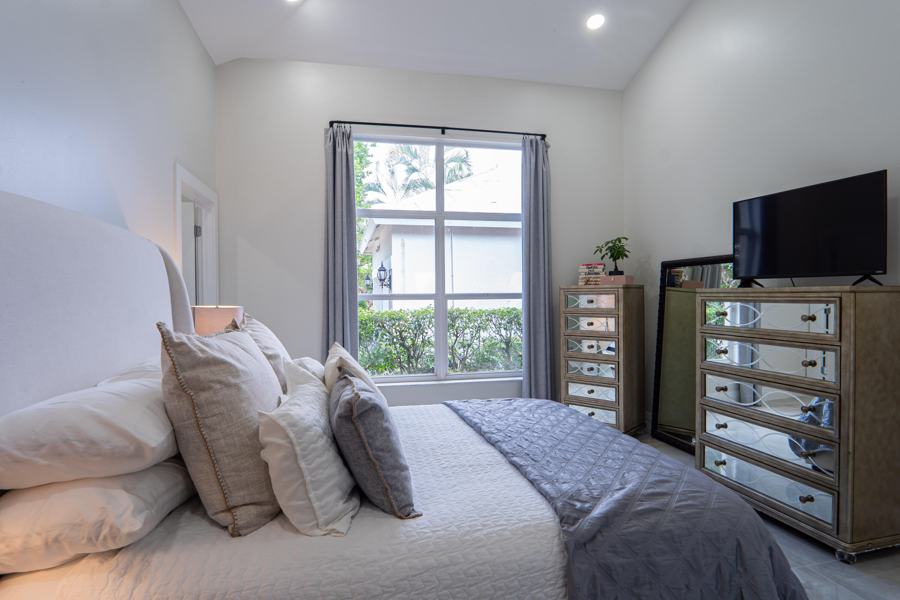 6670 Northwest 27th Avenue Boca Raton, FL 33496 - Photo 23 of 43 a bedroom with a bed and flat screen tv