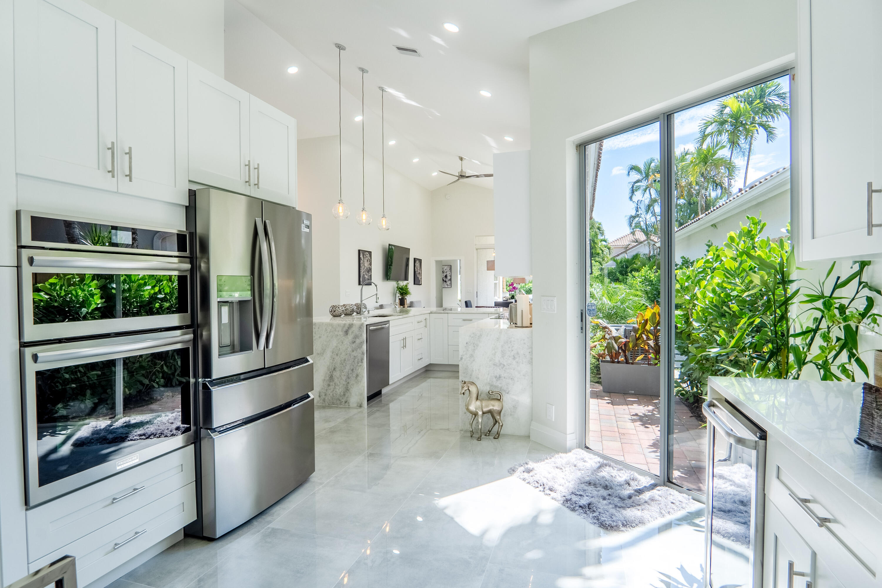 6670 Northwest 27th Avenue Boca Raton, FL 33496 - Photo 28 of 43 a kitchen with stainless steel appliances kitchen island granite countertop a refrigerator and a sink