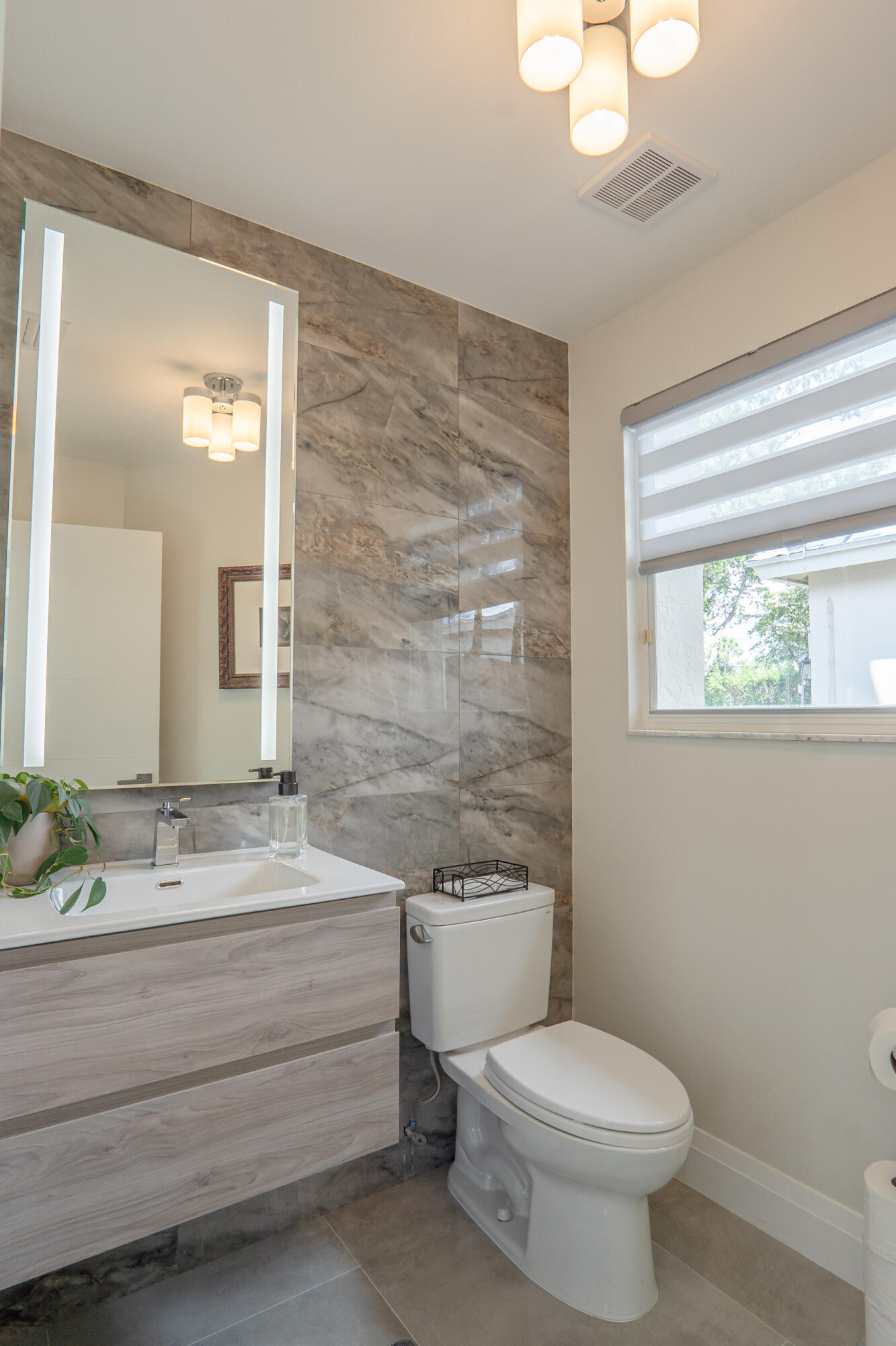 6670 Northwest 27th Avenue Boca Raton, FL 33496 - Photo 33 of 43 a bathroom with a toilet a sink and mirror