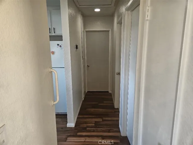 a view of a hallway with wooden floor and entryway