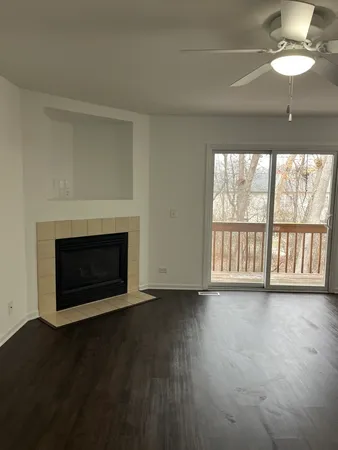 a view of an empty room with a fireplace and a window