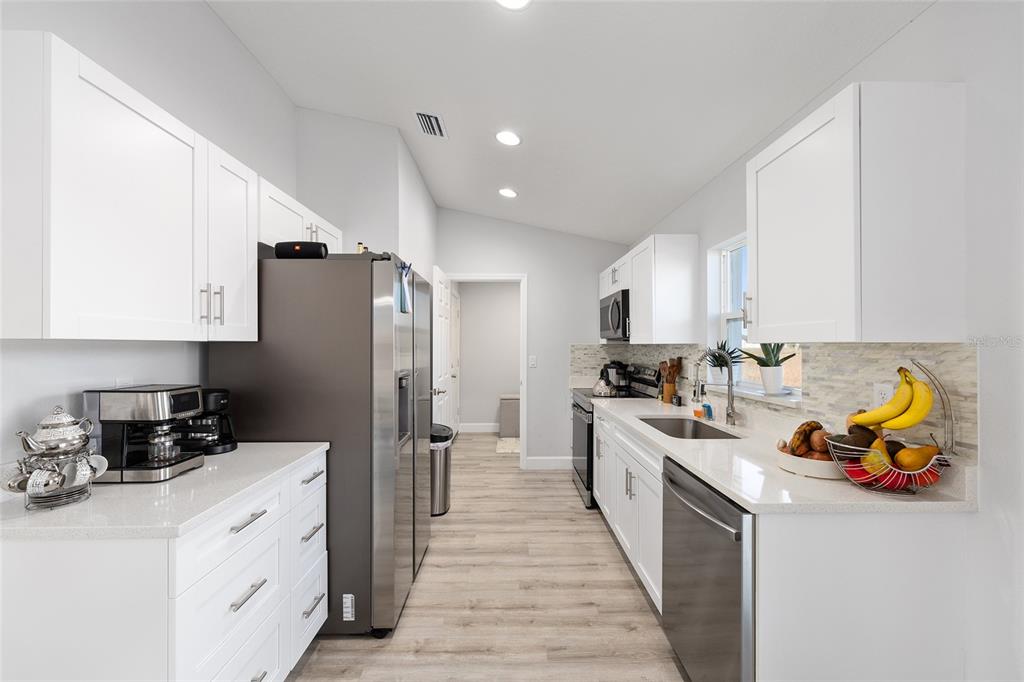 3597 Southwest 151st Avenue Ocala, FL 34481 - Photo 13 of 35 a kitchen with stainless steel appliances a refrigerator sink and white cabinets