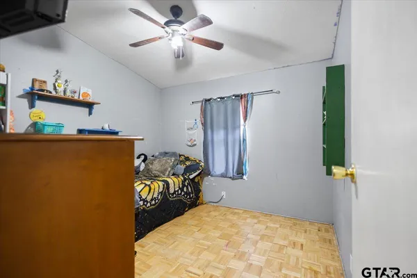 a bed sitting in a bedroom next to a cabinet and a chandelier