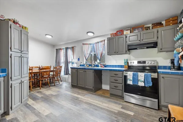 a kitchen with kitchen island granite countertop lots of counter top space and stainless steel appliances