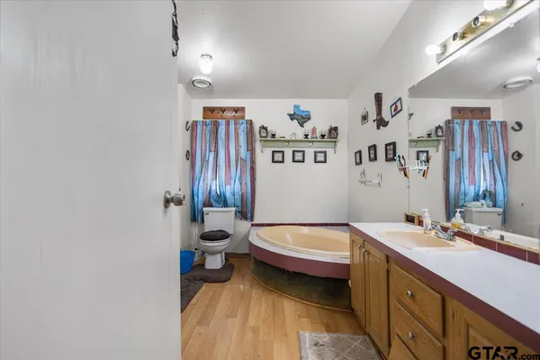 a spacious bathroom with a sink a toilet and a mirror