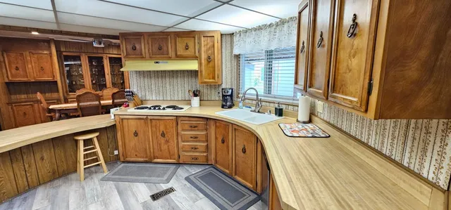 a utility room with stainless steel appliances a sink and cabinets