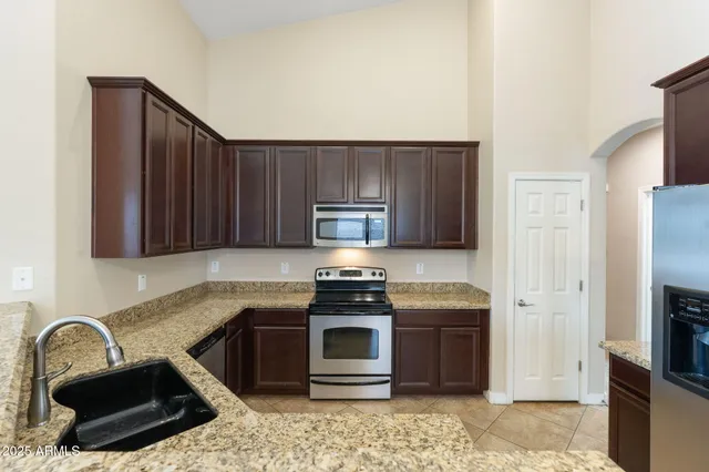 a kitchen with granite countertop a refrigerator stove and microwave