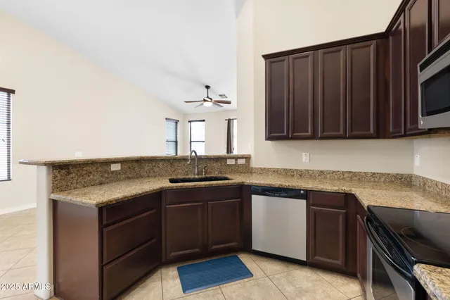 a kitchen with granite countertop a sink stove and microwave