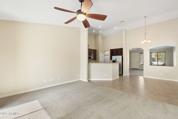 an empty room with a window and a fan