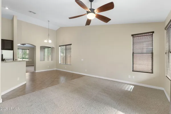an empty room with a chandelier fan