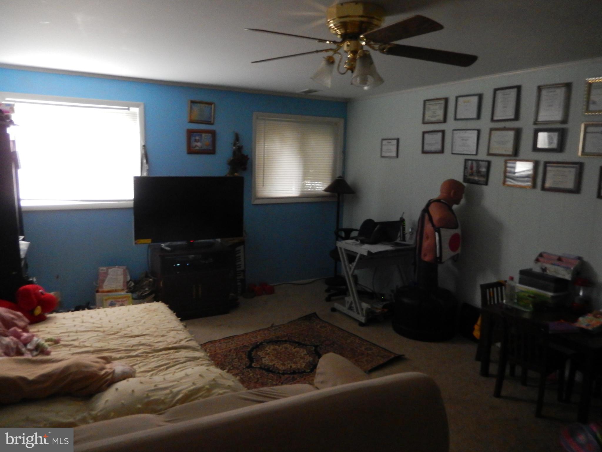 4706 Renn Street Rockville, MD 20853 - Photo 13 of 28 a bedroom with a bed and a flat screen tv