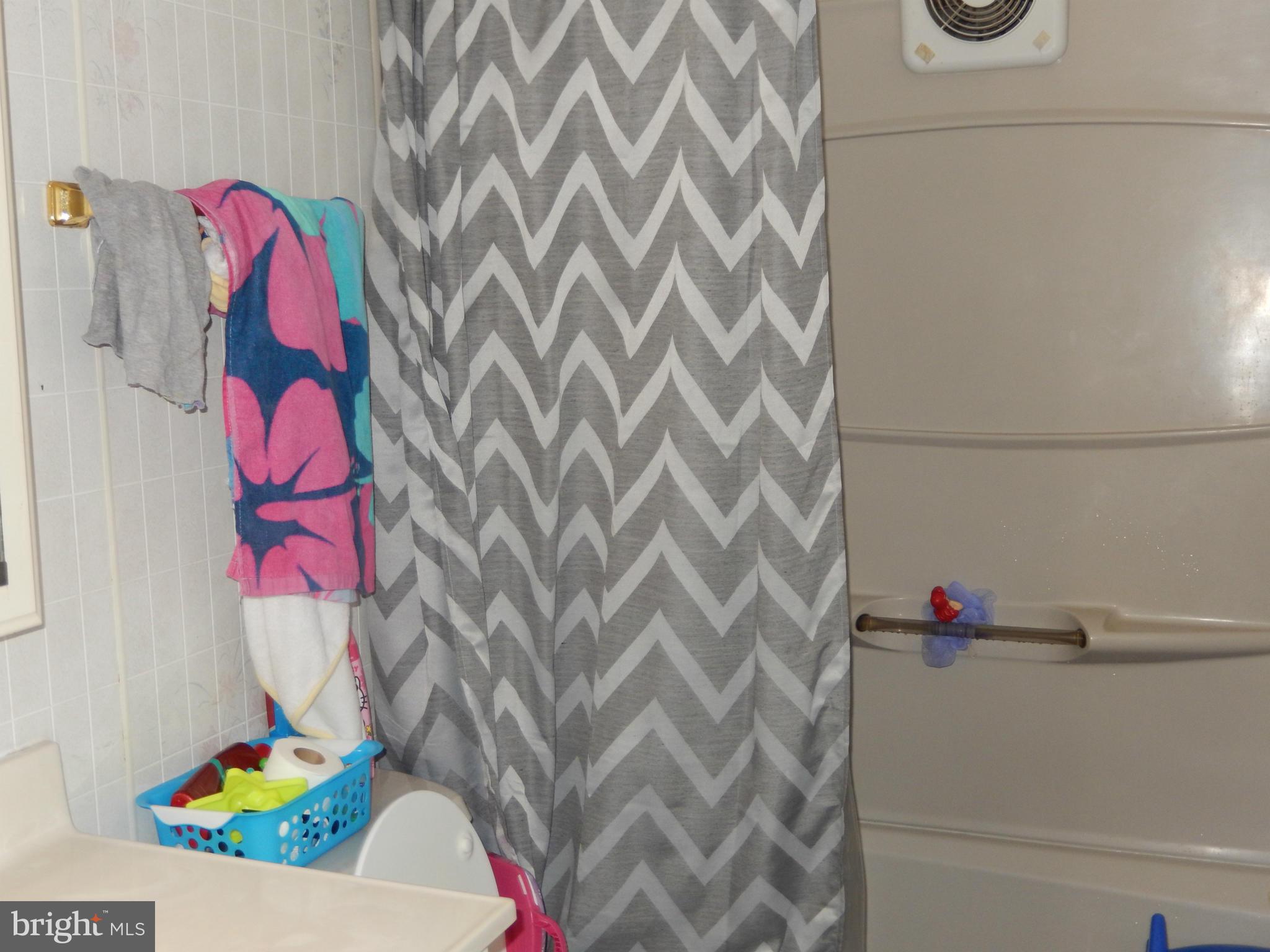 4706 Renn Street Rockville, MD 20853 - Photo 23 of 28 a bathroom with a bathtub and shower curtain