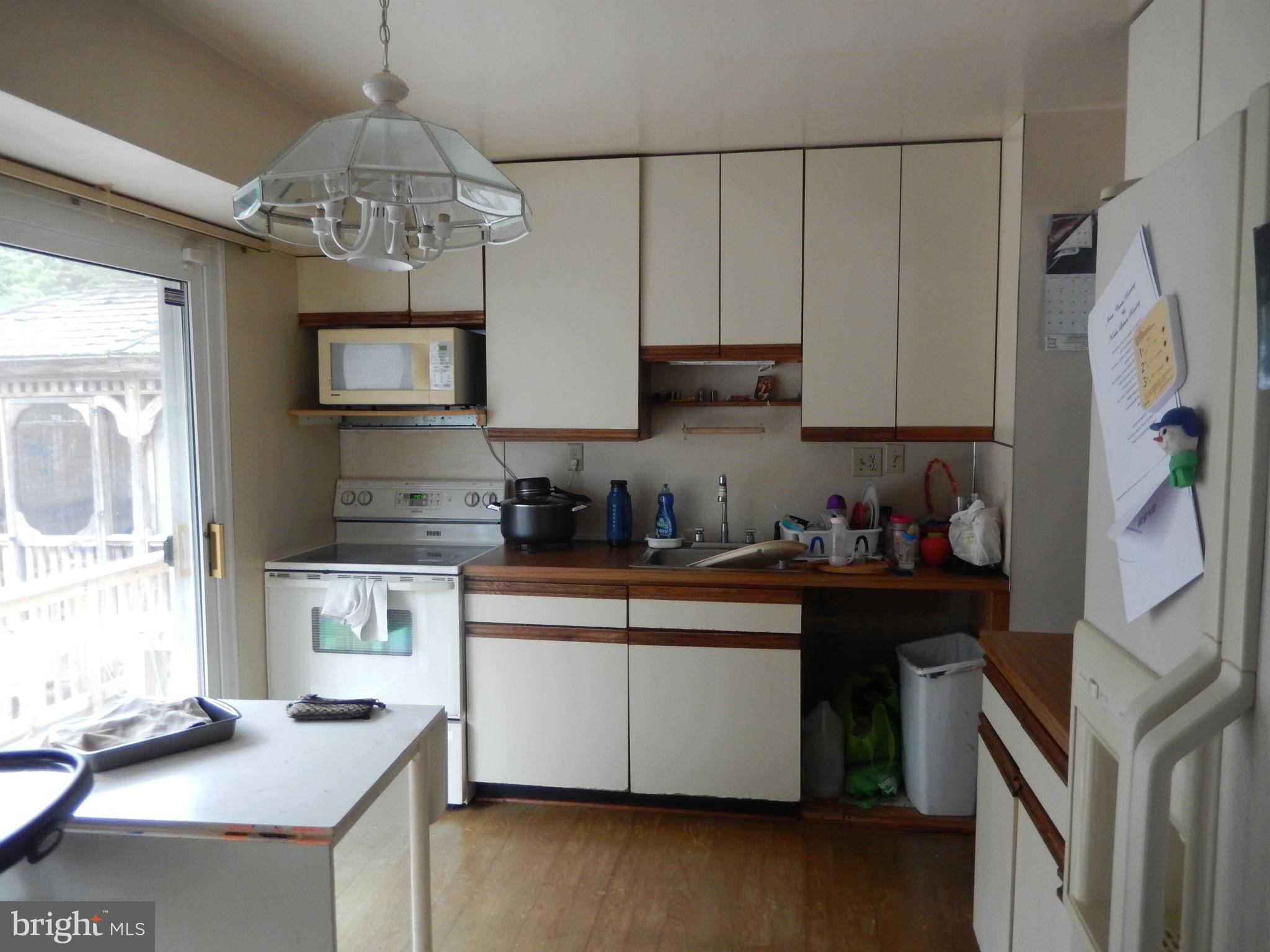 4706 Renn Street Rockville, MD 20853 - Photo 7 of 28 a kitchen with stainless steel appliances granite countertop a stove refrigerator and microwave