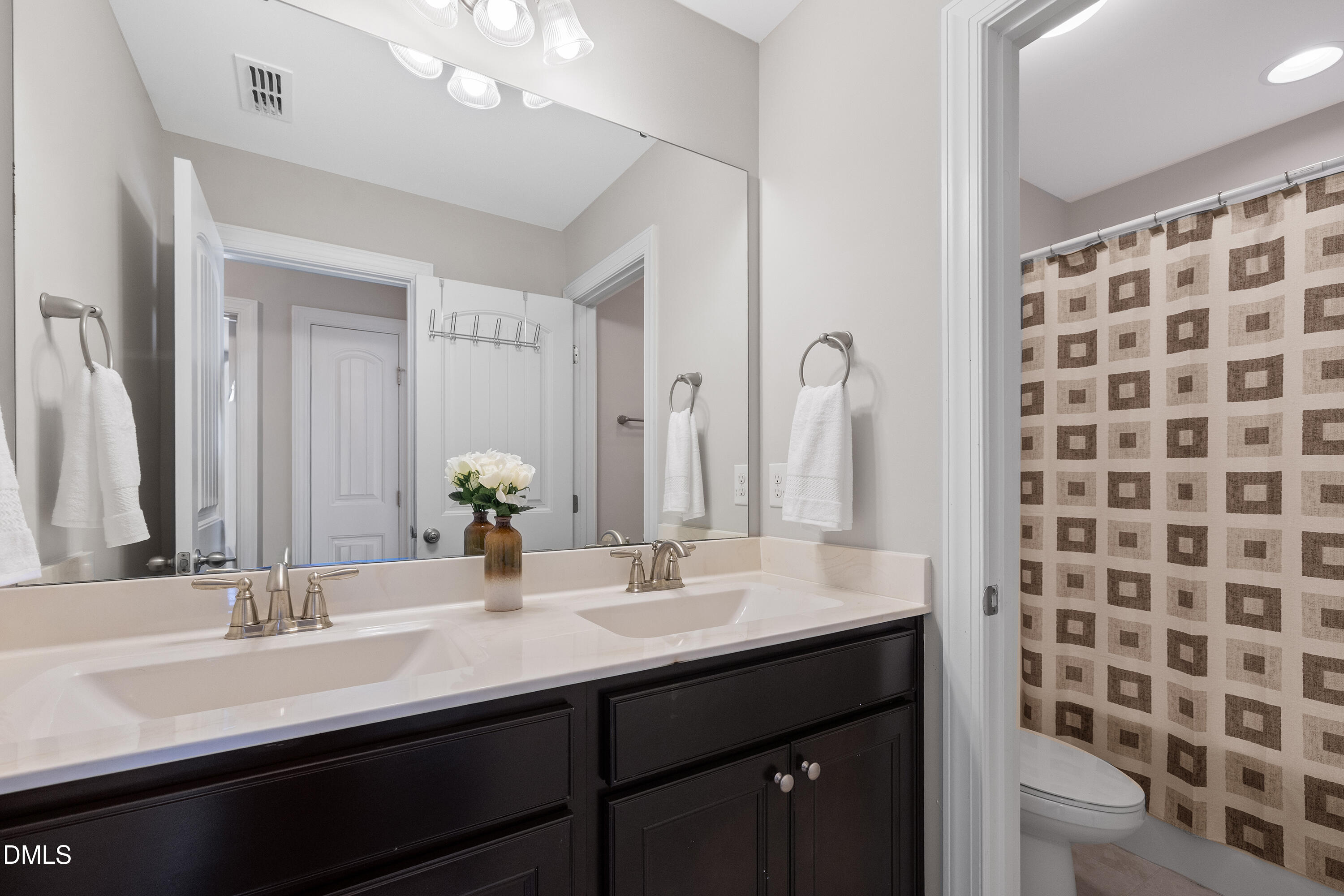 8059 Gilano Drive Raleigh, NC 27603 - Photo 37 of 43 a bathroom with a double vanity sink toilet and a mirror
