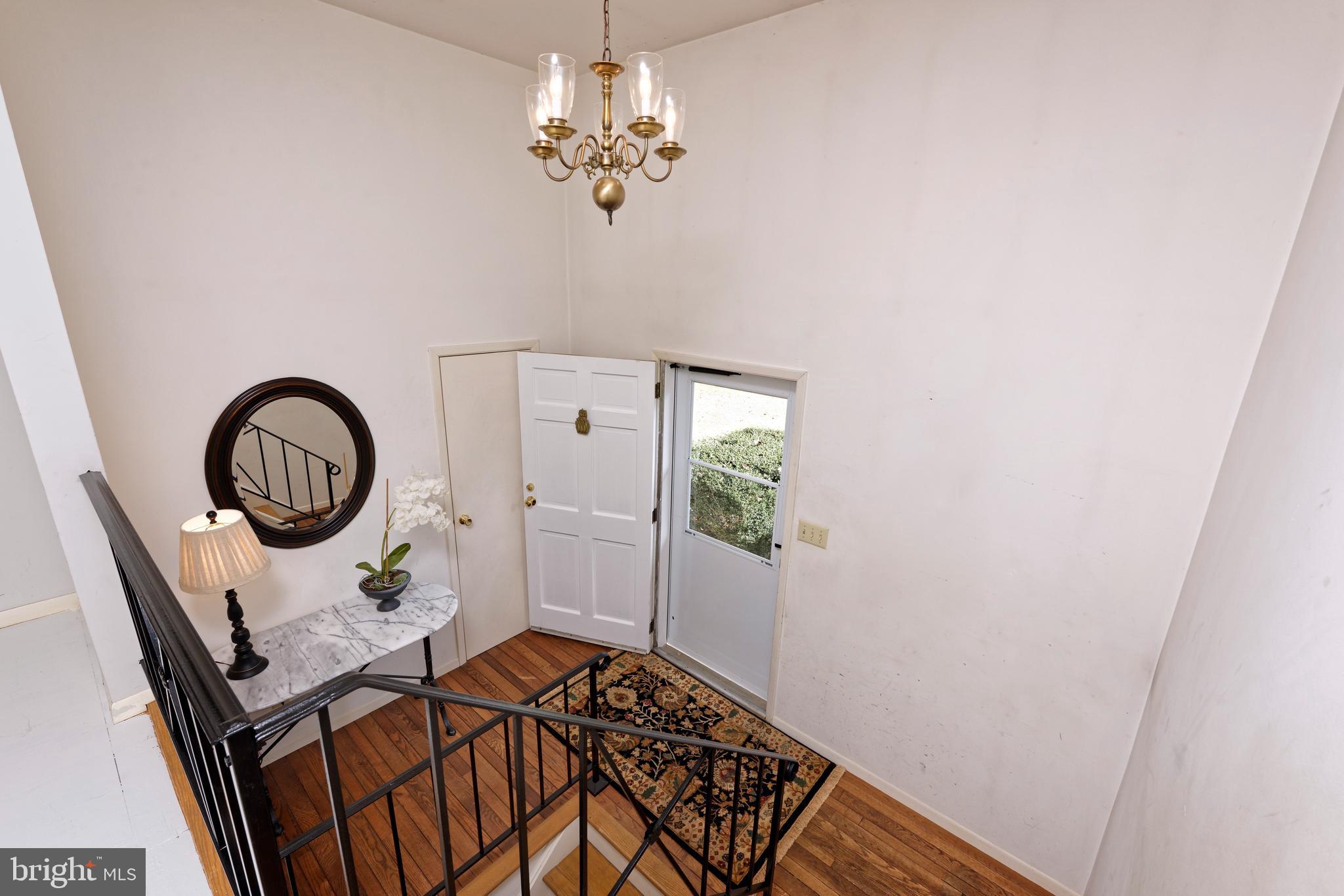 Foyer with hardwood floors & wrought iron railing