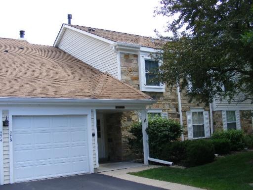 a view of a house with garage and plants