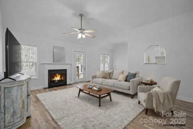 a living room with furniture a fireplace and a flat screen tv