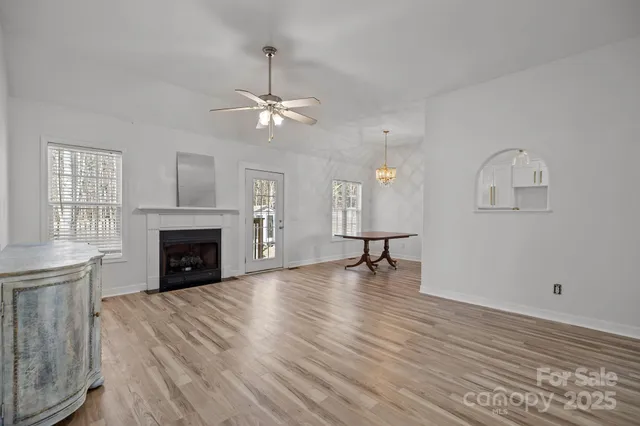 a view of empty room with wooden floor and fireplace