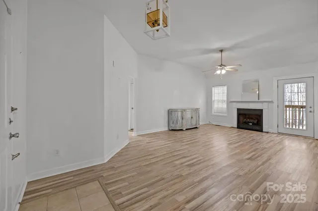 a view of empty room with wooden floor and fireplace