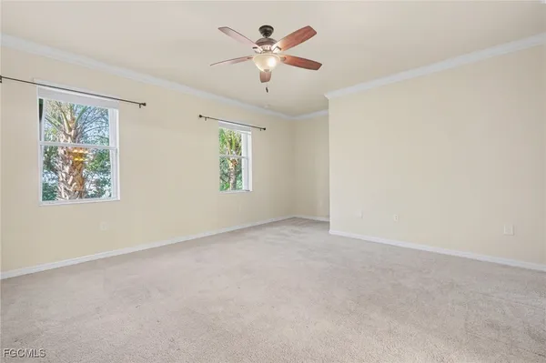 an empty room with windows and fan