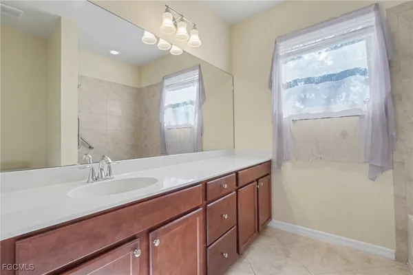 a bathroom with a granite countertop sink a large mirror and a shower