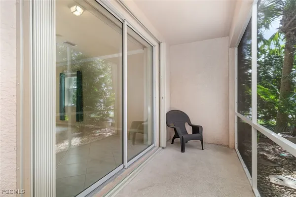 a view of a room that has a large window and chair