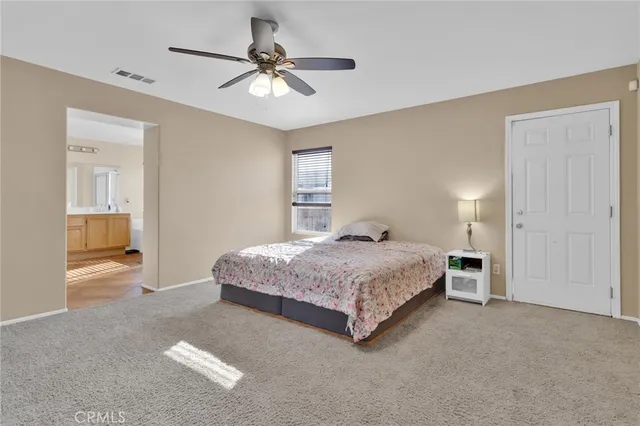 a spacious bedroom with a bed and a chandelier