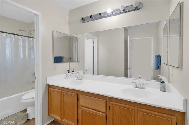 a bathroom with a sink double vanity granite tub and a mirror
