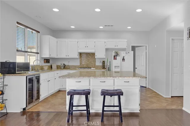 a kitchen with stainless steel appliances kitchen island granite countertop a table and chairs in it