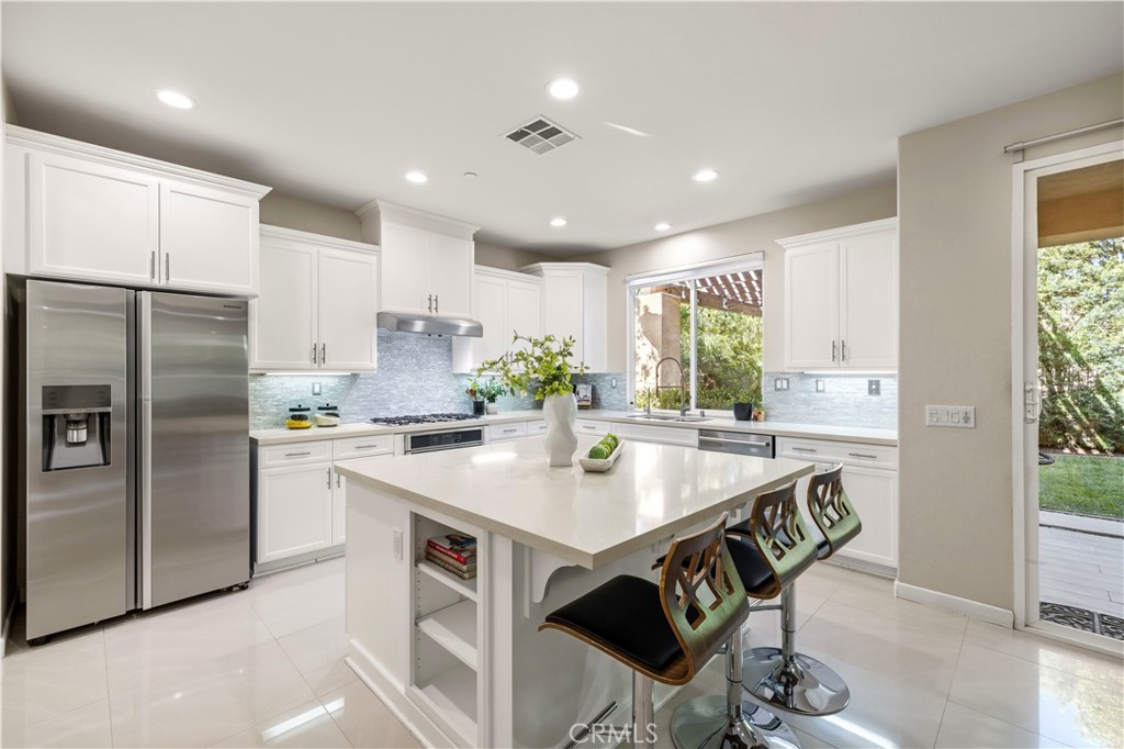 28613 Stonegate Court Valencia, CA 91354 - Photo 11 of 56 a kitchen with kitchen island stainless steel appliances a sink a stove a table and chairs