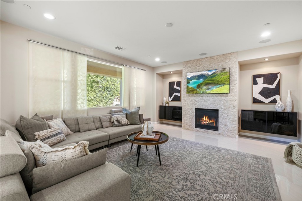 28613 Stonegate Court Valencia, CA 91354 - Photo 16 of 56 a living room with furniture a flat screen tv and a fireplace
